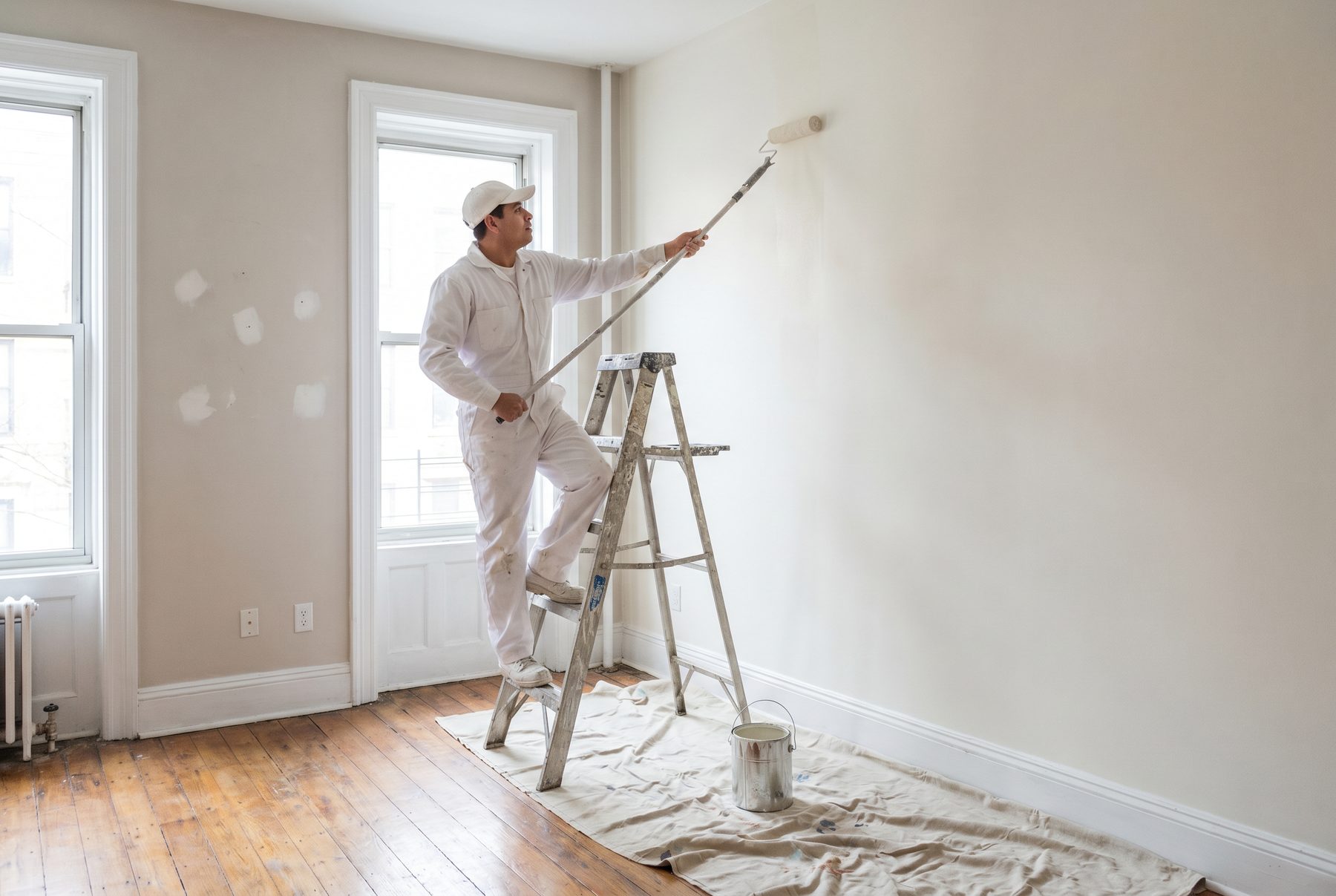 Painter on a ladder finishing a ceiling